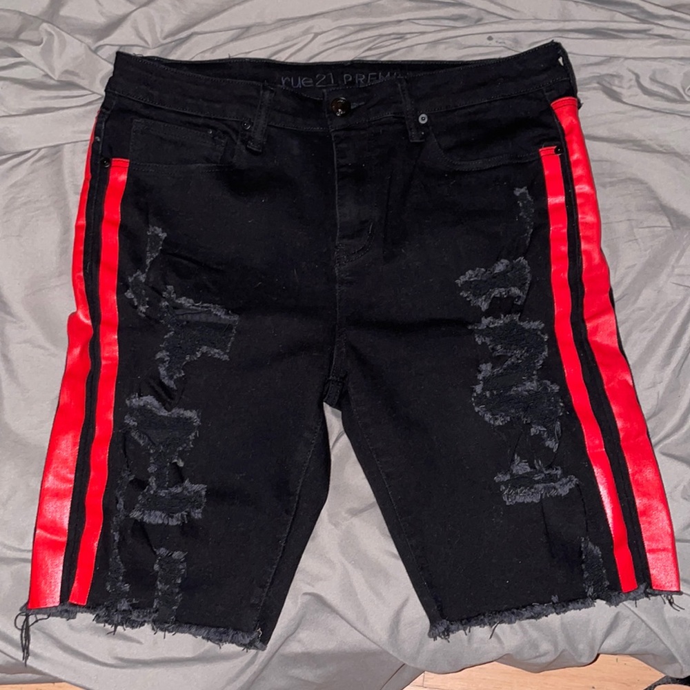 Black ripped shorts with red stripes on the sides